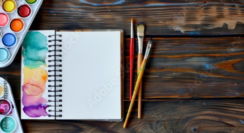 Blank Sketchbook and Watercolor Palette on Wooden Table