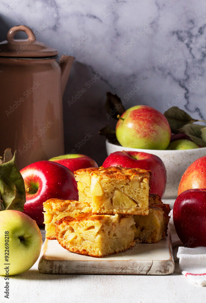 Apple pie, apples and teapot served for tea. Traditional apple dessert.