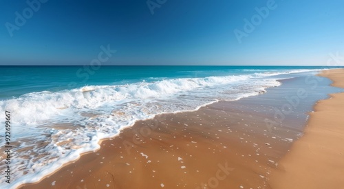 Sunny Beach With Gentle Waves and Clear Blue Sky