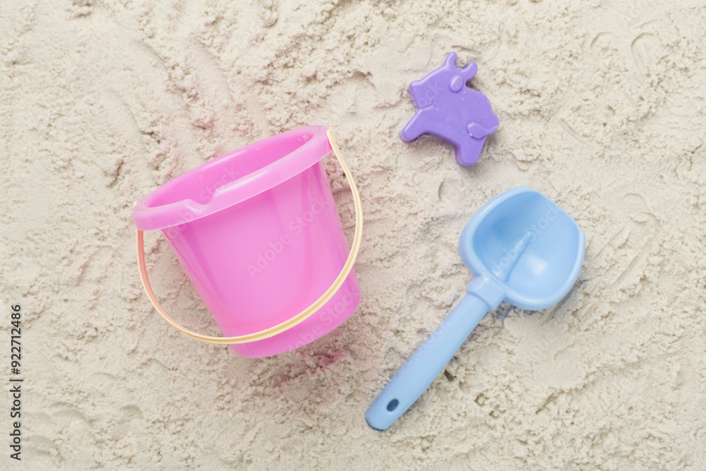 Cute toys for playing on sand background, top view Cute toys for playing on sand background, top view