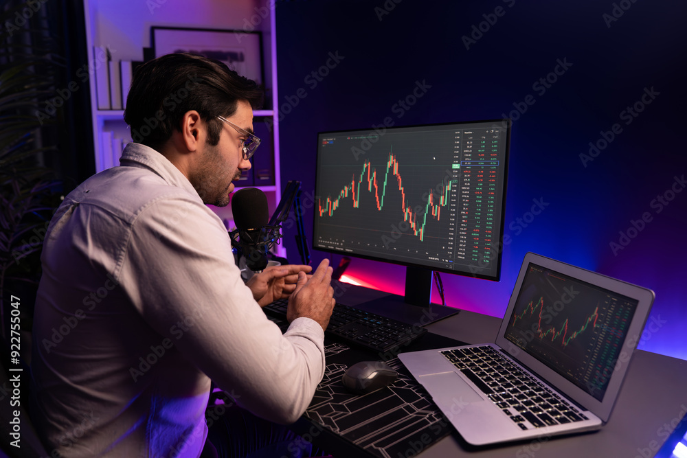 Smart trader businessman concentrating on dynamic stock exchange investment on pc and laptop showing on screen with high profit in searching market at neon light office in dark room night. Surmise. Smart trader businessman concentrating on dynamic stock exchange investment on pc and laptop showing on screen with high profit in searching market at neon light office in dark room night. Surmise.