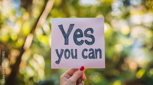 Woman holding yes you can sign with blurred background