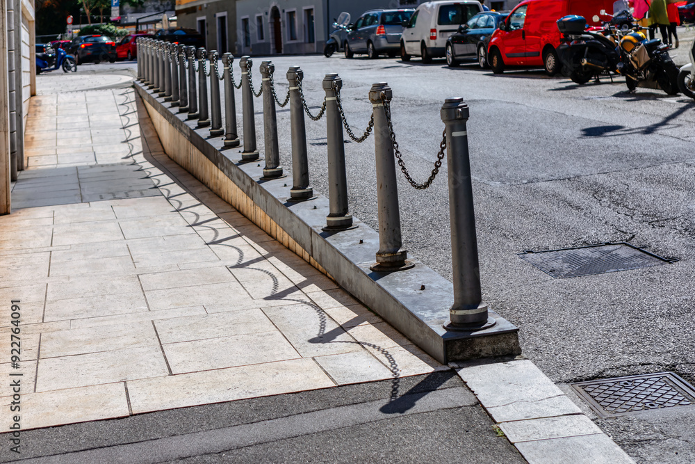 Street scene featuring a metal poles alongside with pavement. City life and safety features
