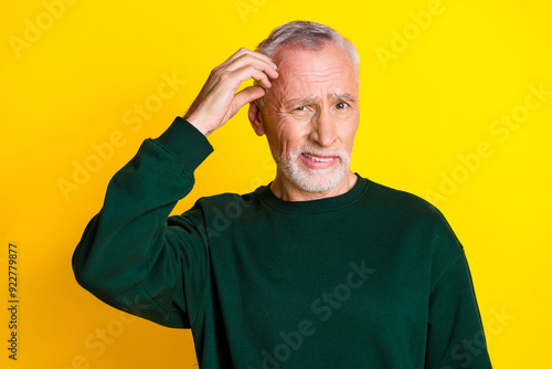 Photo portrait of lovely pensioner man confused scratch head dressed stylish green garment isolated on yellow color background photo