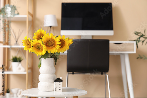 Sunflowers in white vase on...