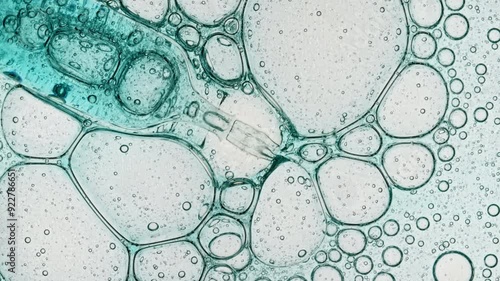 Transparent cosmetic blue gel fluid with molecule bubbles oil spreading on a white background. Macro Shot of Natural Organic Cosmetics, Medicine. Production Close-up. Slow Motion. . High quality 4k 