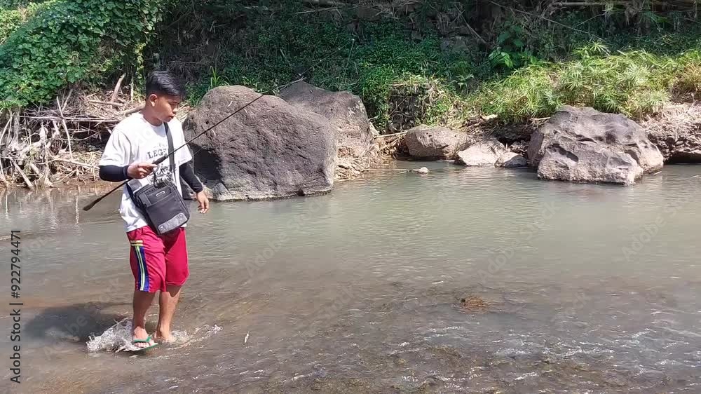 a man who was doing his fishing hobby using casting techniques in a river in the Magelang area, Central Java, Indonesia a man who was doing his fishing hobby using casting techniques in a river in the Magelang area, Central Java, Indonesia