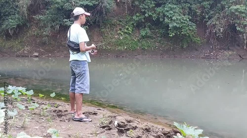 a man who is fishing using a casting technique in a river in the Magelang area, Central Java, Indonesia
 photo