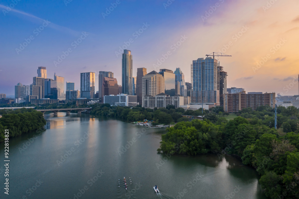 People rowing on the Colorado River and downtown city skyline of Austin at sunrise. Texas, United States. People rowing on the Colorado River and downtown city skyline of Austin at sunrise. Texas, United States.