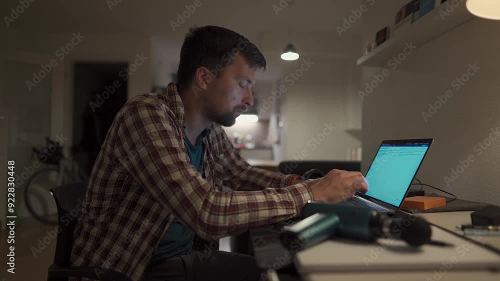 Cervical neck ache, nerve arthritis. Man studying late through night at laptop computer with cervical pain. Exhausted guy relaxing his neck using gun massager while overworking at notebook computer. Cervical neck ache, nerve arthritis. Man studying late through night at laptop computer with cervical pain. Exhausted guy relaxing his neck using gun massager while overworking at notebook computer.
