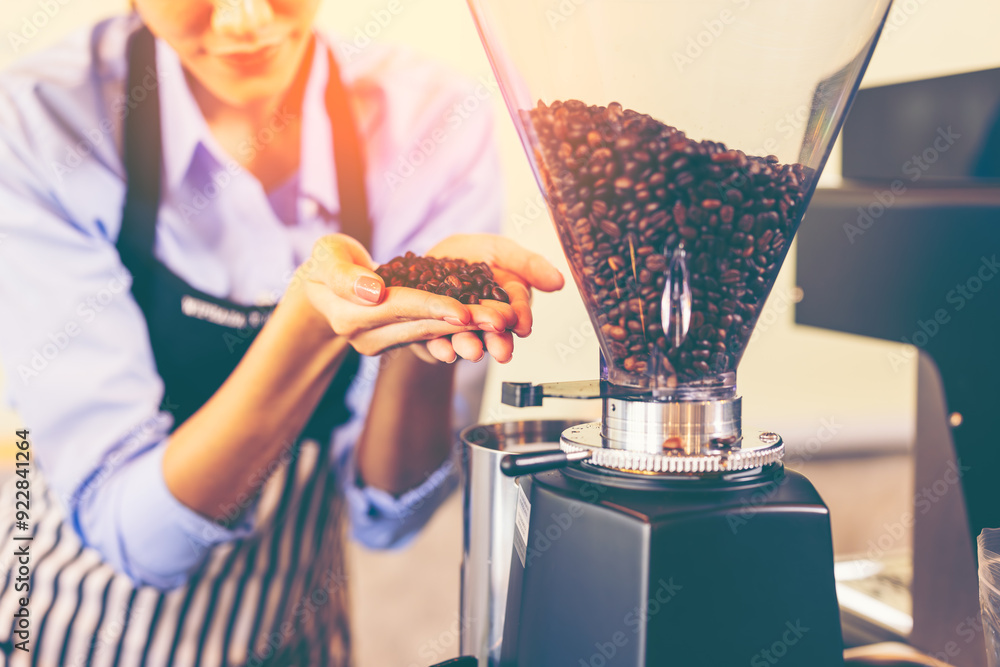 Obraz premium Asian woman entrepreneur making coffee from machine while standing by coworker at cafe. Female barista making coffee in coffee shop counter. Takeaway food. Professional coffee making. Small business.