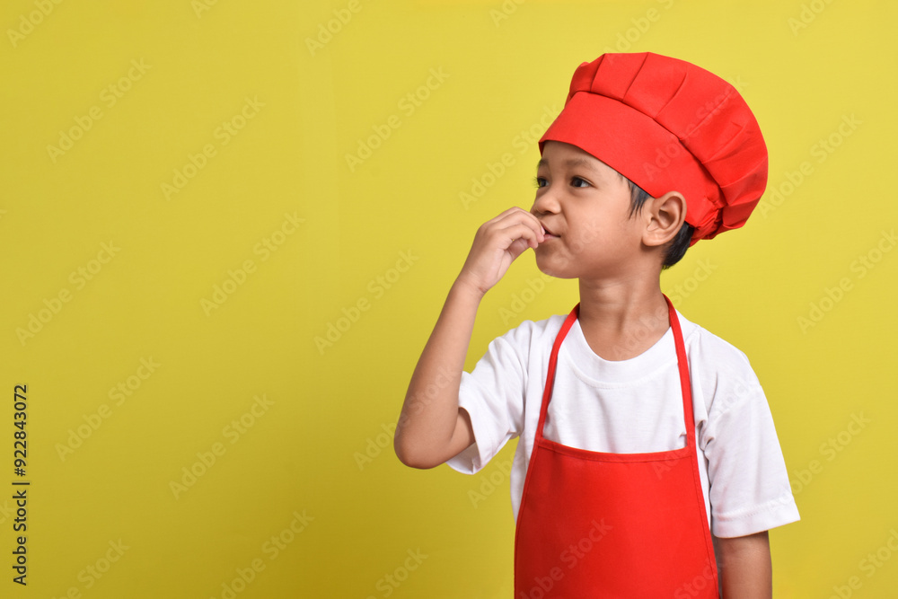 Cute little chef showing perfect sign isolated on yellow background. Asian boy wearing red apron and hat Cute little chef showing perfect sign isolated on yellow background. Asian boy wearing red apron and hat