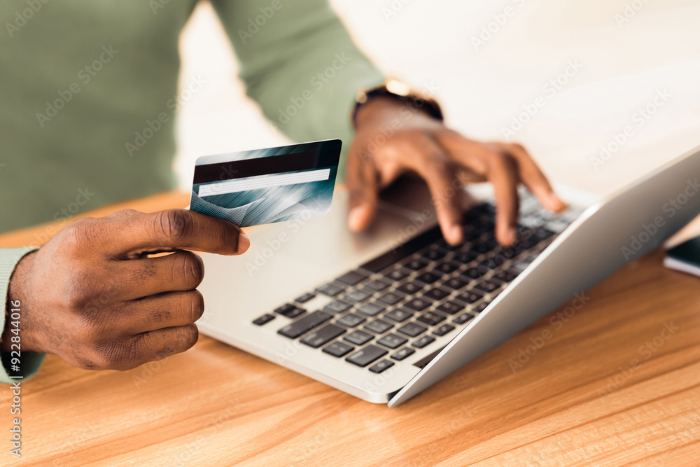 Money Transfer. Unrecognizable african guy holding plastic credit card and using laptop. Copyspace Money Transfer. Unrecognizable african guy holding plastic credit card and using laptop. Copyspace
