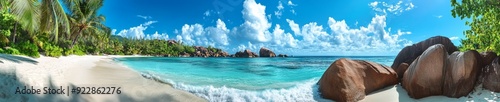 Stunning tropical beach from Anse Lazio in Seychelles. The view includes a pristine white sand beach surrounded by large, smooth granite boulders.