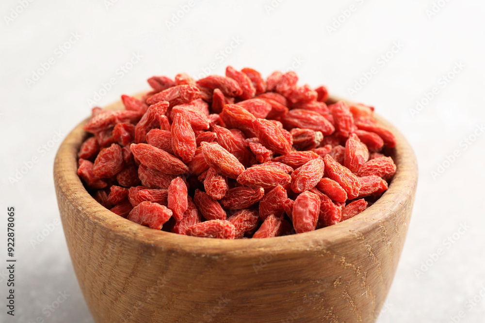 Dried goji berries in bowl on light grey table, closeup Dried goji berries in bowl on light grey table, closeup