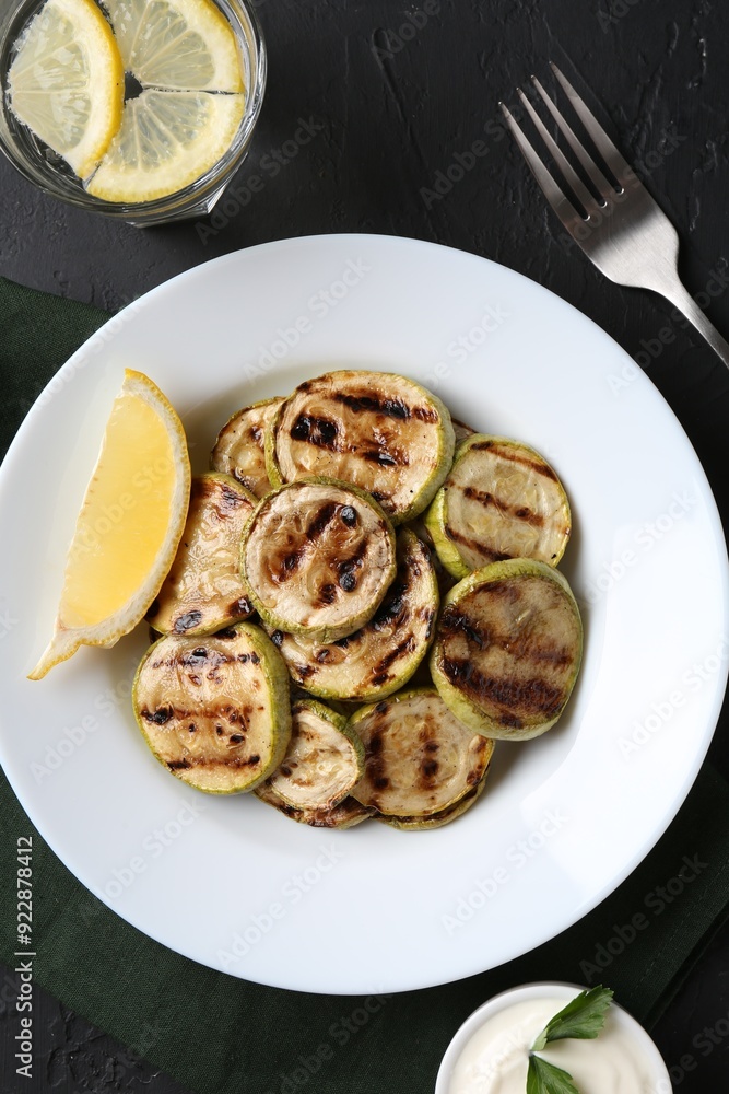 Tasty grilled zucchini slices served on black textured table, flat lay Tasty grilled zucchini slices served on black textured table, flat lay