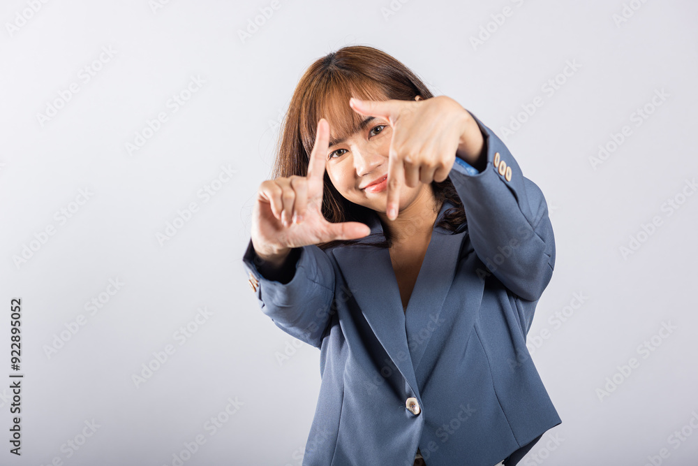 Portrait of a happy young business woman photographer framing with her finger in front of her face, capturing the concept of photography. Studio shot on white background, viewfinder sign Portrait of a happy young business woman photographer framing with her finger in front of her face, capturing the concept of photography. Studio shot on white background, viewfinder sign