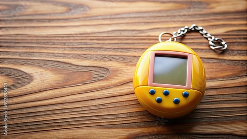 Close-up of a Tamagotchi digital pet sitting on a wooden table, Tamagotchi, digital pet, table, wooden, close-up, technology photo