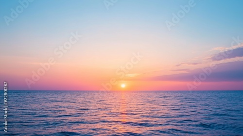 Sunset over the calm ocean waters at dusk with colorful sky hues reflecting on the surface.