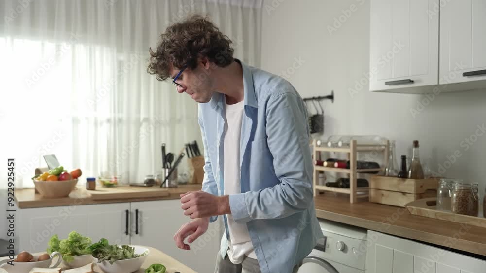 Happy father move to music while cooking food and prepare lunch at modern kitchen. Active dad dancing to song while making healthy food or salad surrounded with vegetable and kitchenware. Pedagogy. Happy father move to music while cooking food and prepare lunch at modern kitchen. Active dad dancing to song while making healthy food or salad surrounded with vegetable and kitchenware. Pedagogy.