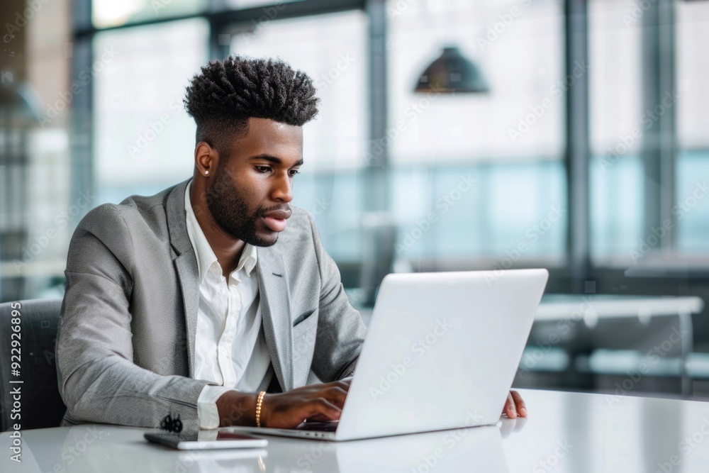 A man in a suit is typing on a laptop computer A man in a suit is typing on a laptop computer