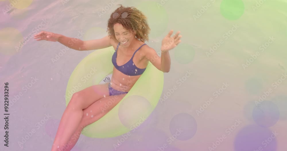 Smiling woman floating in pool on inflatable ring with colorful animation overlay Smiling woman floating in pool on inflatable ring with colorful animation overlay