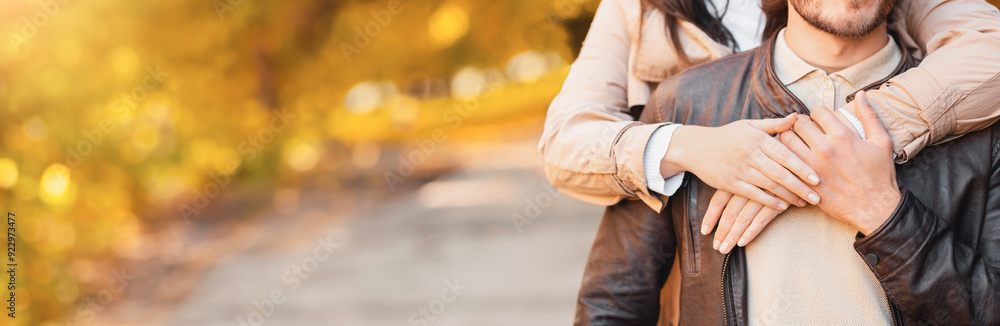 Love, affectionate concept. Girl hands hugging boyfriend from behind, park background, panorama with copy space Love, affectionate concept. Girl hands hugging boyfriend from behind, park background, panorama with copy space
