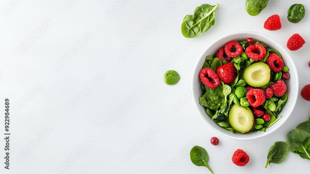Fresh salad featuring spinach, avocado, raspberries, and nuts, perfect for healthy eating and vibrant cooking.