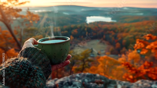 A cup of green tea in hand overlooking a landscape painted in the hues of fall . Looping 4k video animation background photo