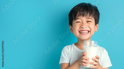 A happy little kid drink milk from glass