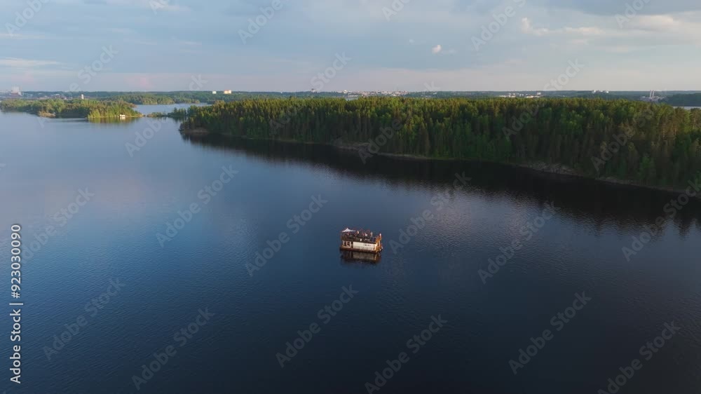 Aerial view orbiting a sauna boat on lake Saimaa, summer sunset in Finland Aerial view orbiting a sauna boat on lake Saimaa, summer sunset in Finland