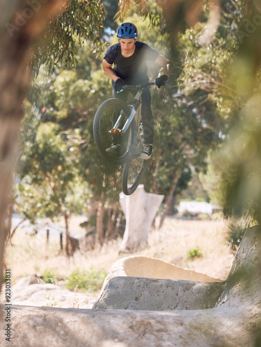 Sports, trail and man jump on bicycle for training, competition and exercise in countryside. Fitness, cycling and person on mountain bike in air for adventure, freedom and adrenaline on dirt path photo