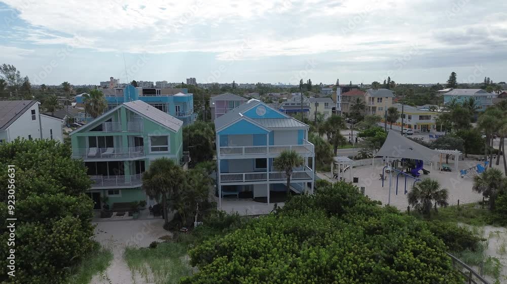 A blue coastal house sits on the edge of paradise, with no one to enjoy it. Boarded up with hurricane shutters on. A blue coastal house sits on the edge of paradise, with no one to enjoy it. Boarded up with hurricane shutters on.