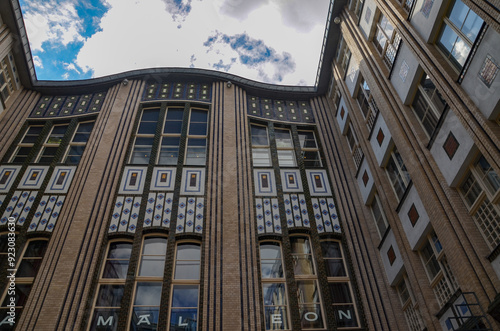 The façade of the house with large windows and a blue sky above it. Hackesche Hoefe is a notable courtyard complex located adjacent to Hackescher Markt in the center of Berlin.