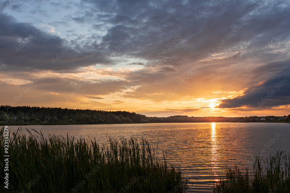 A lake with a sunset in the background A lake with a sunset in the background