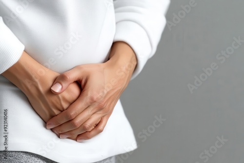 A person pressing their hand against their side, highlighting persistent abdominal pain