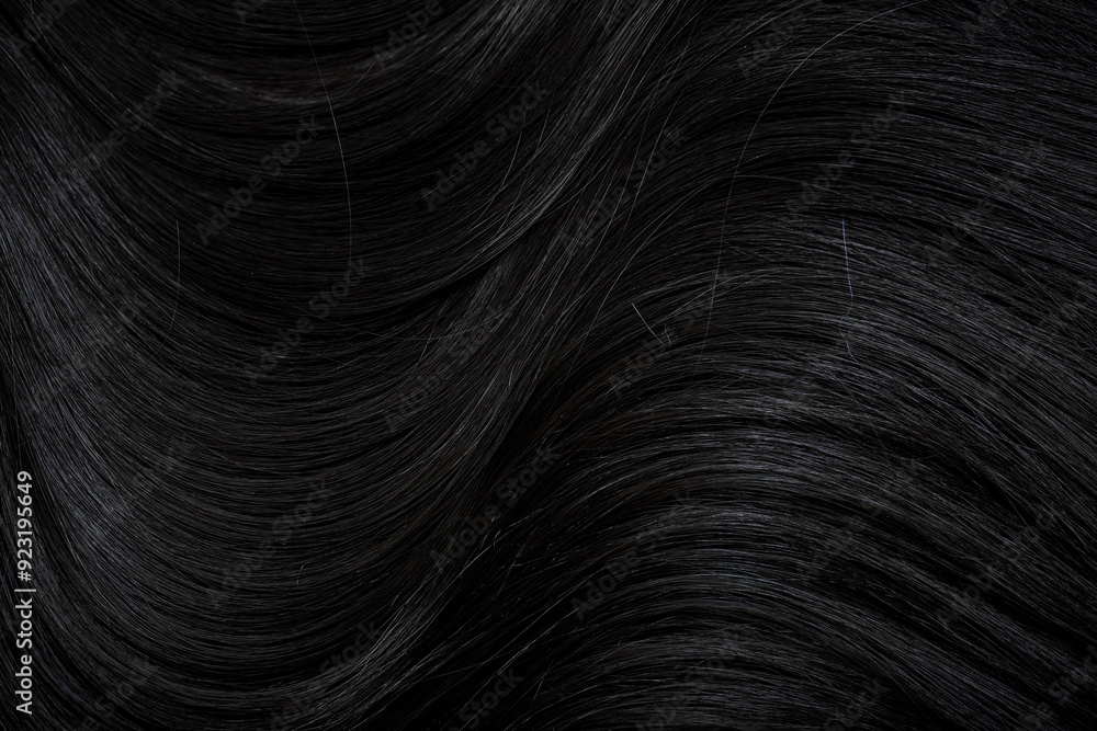 Naklejka premium Brunette or black hair. Female long dark hair in black. Beautifully laid curls. Closeup texture in a dark key. Hairdressing, hair care and coloring. Shading gray hair. Background with copy space.
