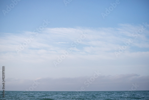 Blue sea and blue sky with white clouds. Seascape.