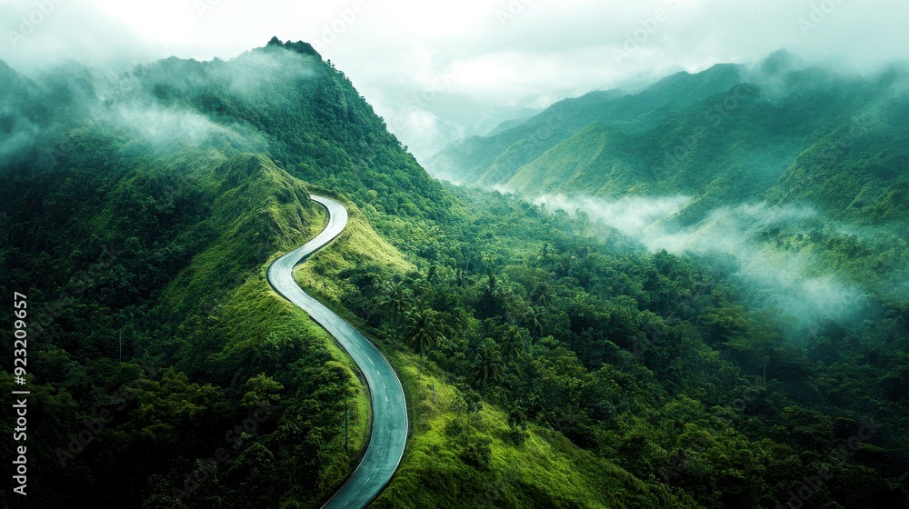 A serpentine road curves through vibrant, green hills shrouded in mist, creating a serene and mysterious atmosphere at dawn A serpentine road curves through vibrant, green hills shrouded in mist, creating a serene and mysterious atmosphere at dawn