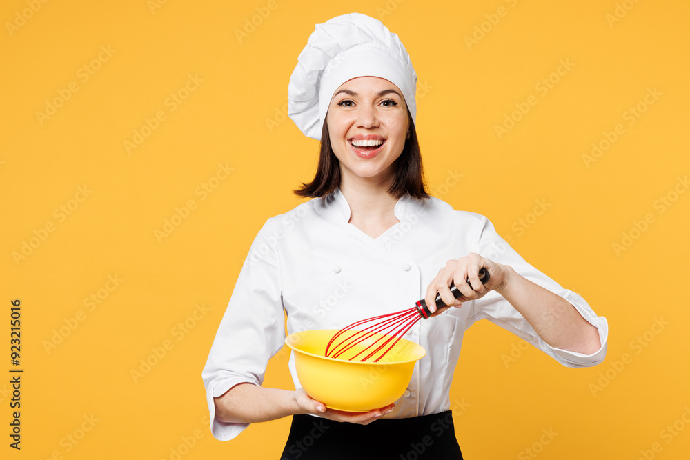 Young shocked fun chef cook baker woman wear white shirt black apron uniform toque chefs hat hold in hand bowl whisk for beating yolks isolated on plain yellow background studio. Cooking food concept. Young shocked fun chef cook baker woman wear white shirt black apron uniform toque chefs hat hold in hand bowl whisk for beating yolks isolated on plain yellow background studio. Cooking food concept.