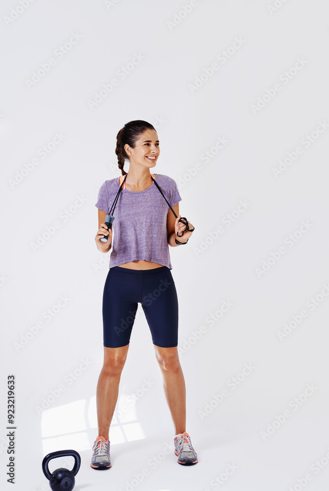 Exercise, kettlebell and woman with fitness, smile and training on white studio background. Happy person, model and athlete with equipment, wellness and cardio with skipping rope, tired and sweating Exercise, kettlebell and woman with fitness, smile and training on white studio background. Happy person, model and athlete with equipment, wellness and cardio with skipping rope, tired and sweating