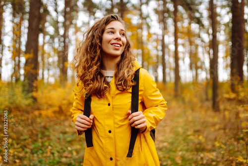 Active young woman carrying backpack enjoying beautiful autumn day outdoors. Autumn landscape. Calmness and tranquility. Travel, tourism concept.