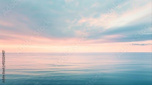 Peaceful seascape with a soft pink and blue sky and calm water.