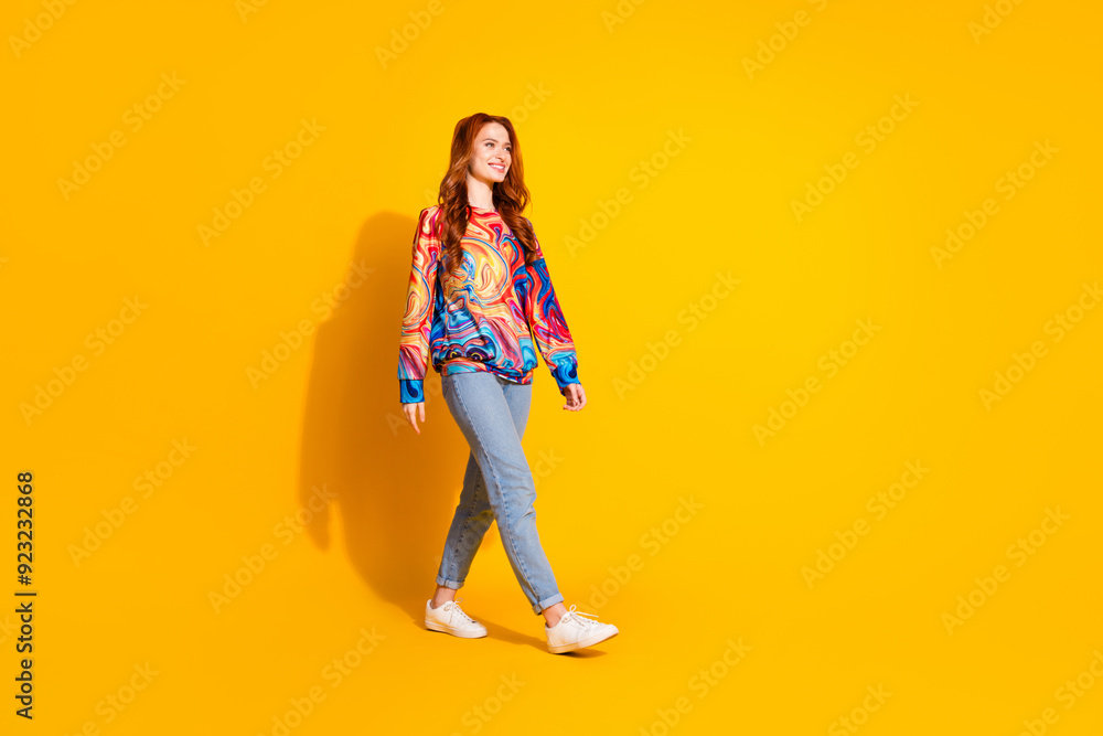 Photo of cheerful lovely nice girl wear trendy print clothes look empty space isolated on vivid yellow color background Photo of cheerful lovely nice girl wear trendy print clothes look empty space isolated on vivid yellow color background