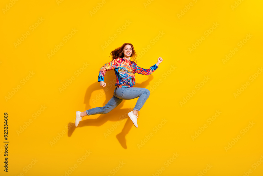 Obraz premium Full size photo of optimistic positive girl dressed print shirt jeans running on sale to empty space isolated on yellow color background