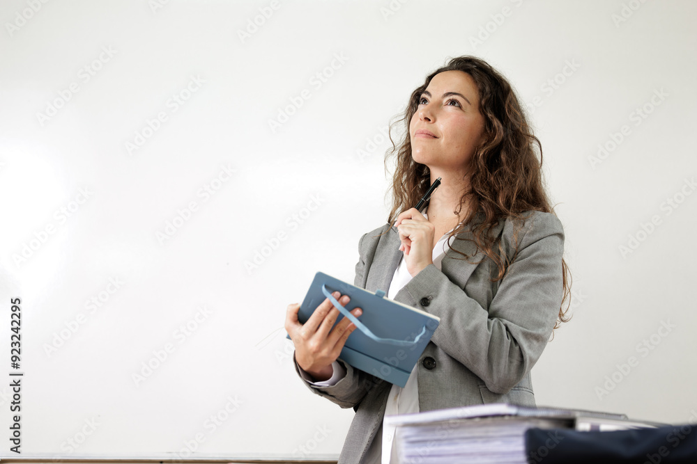 Creative woman writing in her diary to plan schedules, tasks or agenda in teacher classroom. Business woman writes notes for discussion, brainstorming or startup at workplace. Creative woman writing in her diary to plan schedules, tasks or agenda in teacher classroom. Business woman writes notes for discussion, brainstorming or startup at workplace.