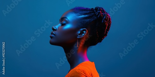  Fashion portrait differences. Ethnicity fashion background. Profile of woman braided hair in vibrant colors, gradient warm cool lighting on dark blue background. Women pride and diversity inclusion