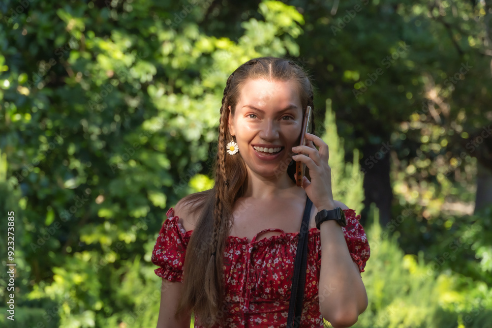 Effortless Elegance: Redhead Laughs While Walking Through a Sunlit Garden on Her Phone Effortless Elegance: Redhead Laughs While Walking Through a Sunlit Garden on Her Phone
