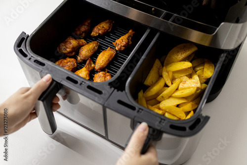 Close-up of fries (Potato wedges) and chicken wings cooked in an air fryer