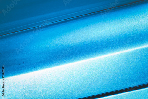 A blue car with a shiny paint job. The car is parked in a parking lot